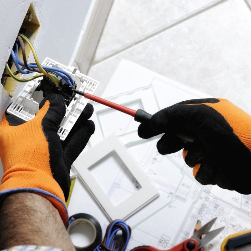 Electrician working safely on switches and sockets of a residential electrical system